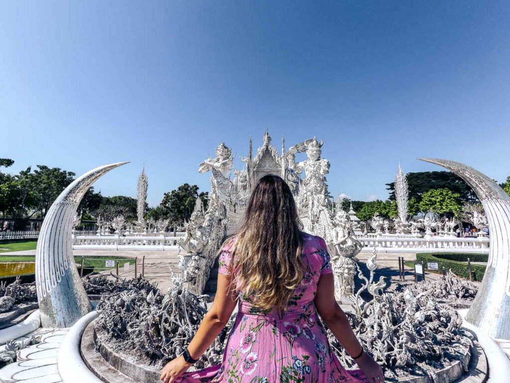 South East Asia must visit Temples Bridge of Rebirth at Wat Rong Khun with ghostly hands reaching up symbolising suffering and rebirth