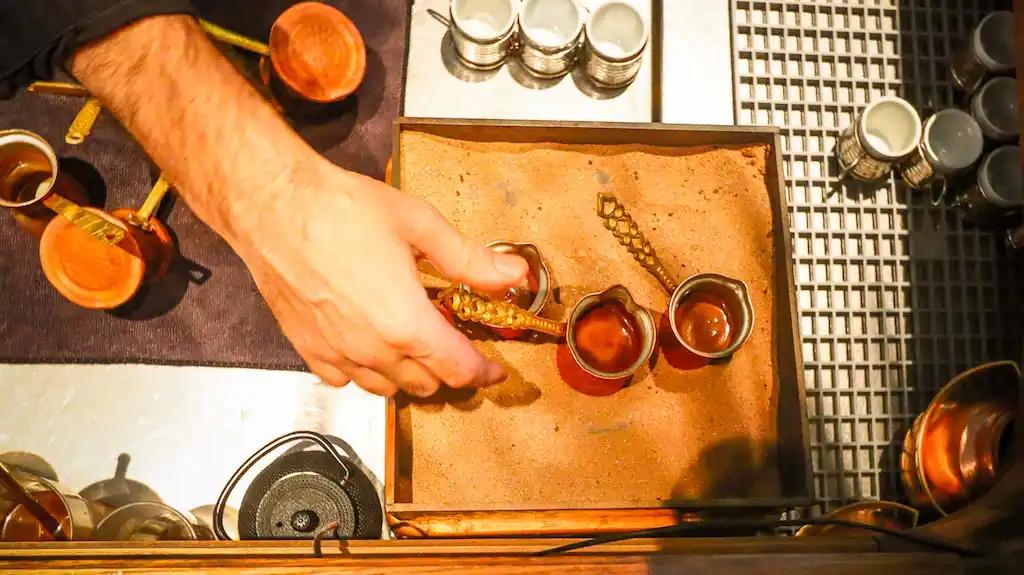 Traditional way of making coffee in Athens in copper cups heated on sand