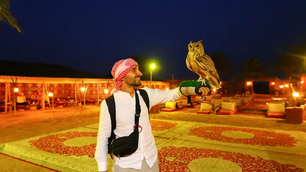 Toti holding a owe A proper Dubai itinerary must include a half day in the desert with a visit to a Bedouin Camp - We explored the reservoir next to Dubai and watched the Eagle show.