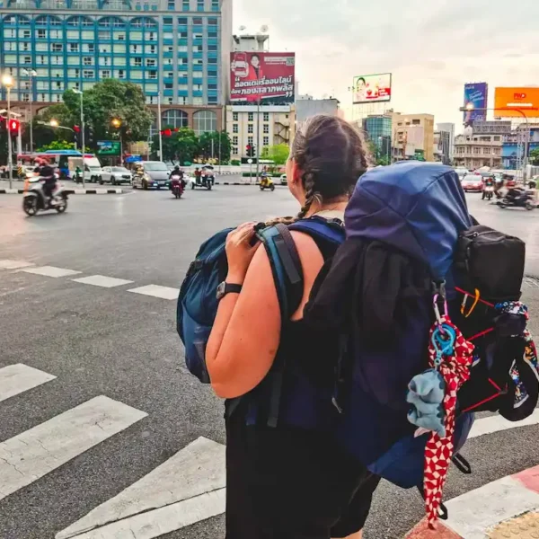 Ale with her 40 litres backpack in Bangkok Thailand crossing the road