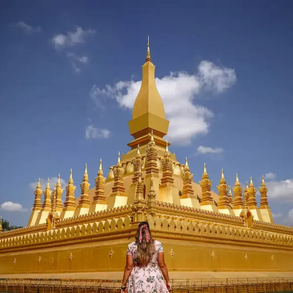 Alessia Passport and Stamps walking toward the Golden Stupa national monument of Laos in Vientiane