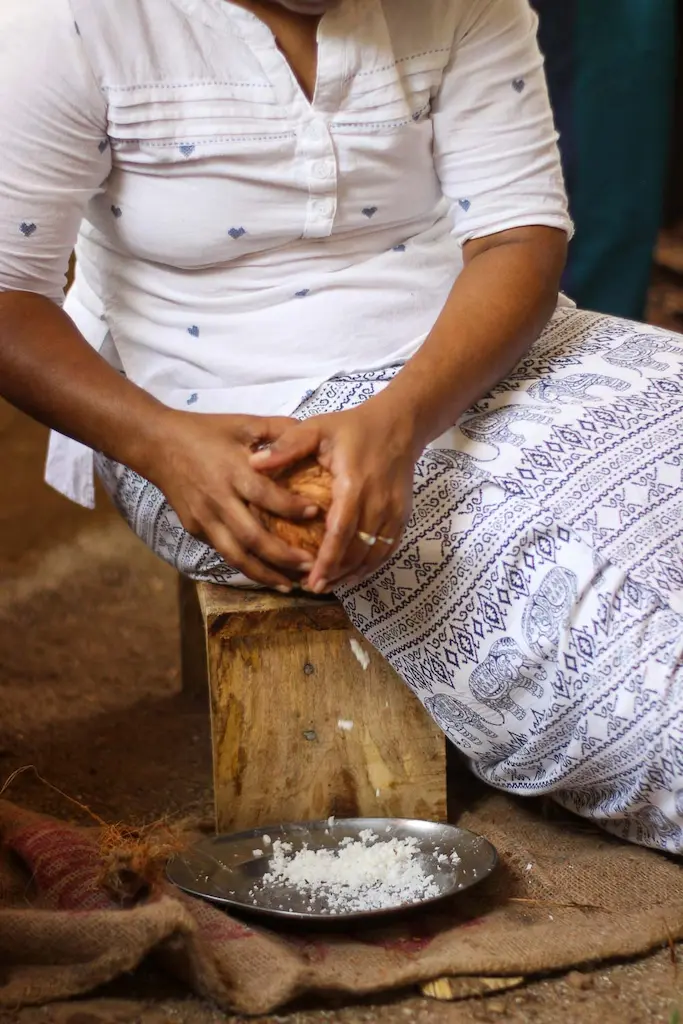 A local sri lankan lady making slices of coconut at our cooking class