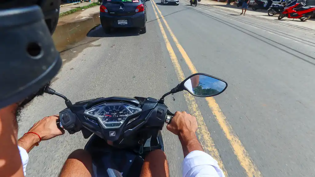 Driving a honda vario through the main strip of Nusa Penida by the ferry port