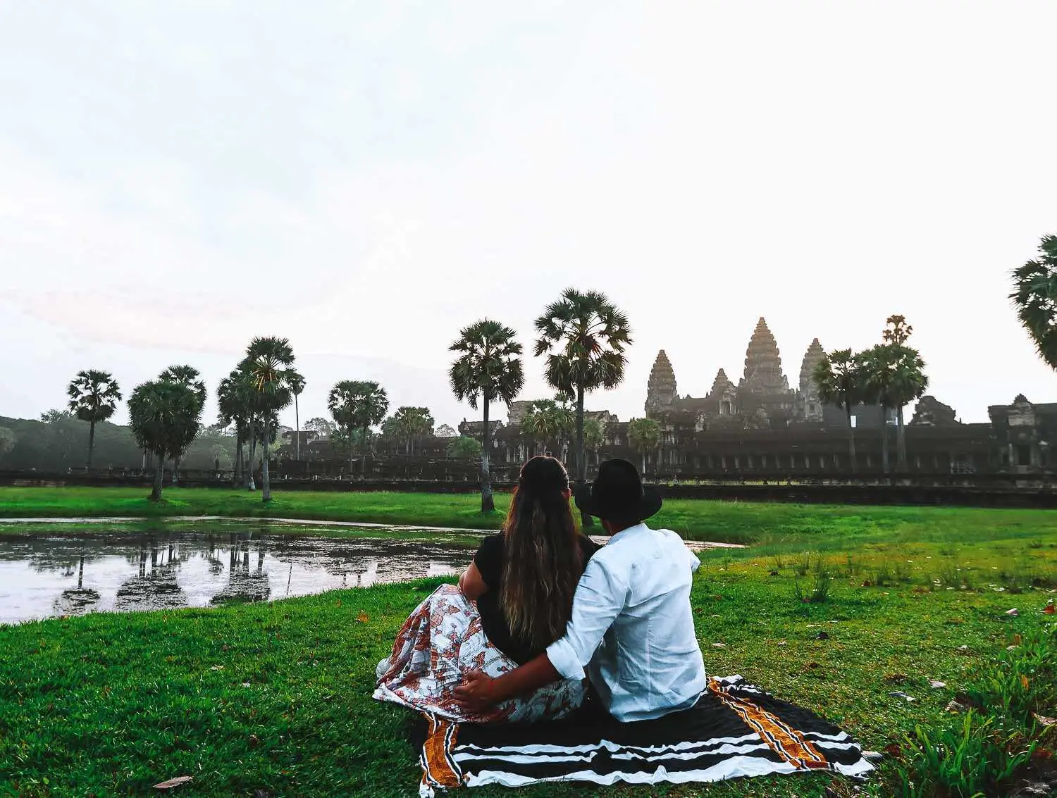 Angkor Watt sunrise by the lake couple shot A couple by the lake watching the sunrise at Angkor Wat Unesco Park