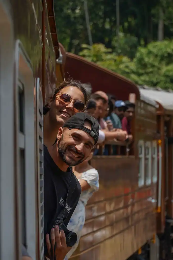 Toti and Ale hanging outside the door of the train in Sri Lanka | Passport and Stamps