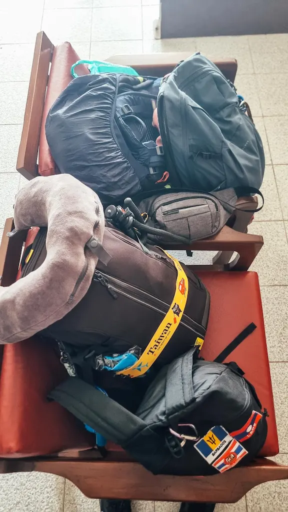 Our backpacks on a bench in a bus station in Thailand