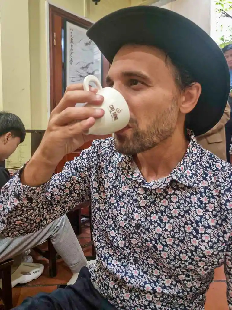 Toti drinking an egg coffee in one of Hanoi best coffee places