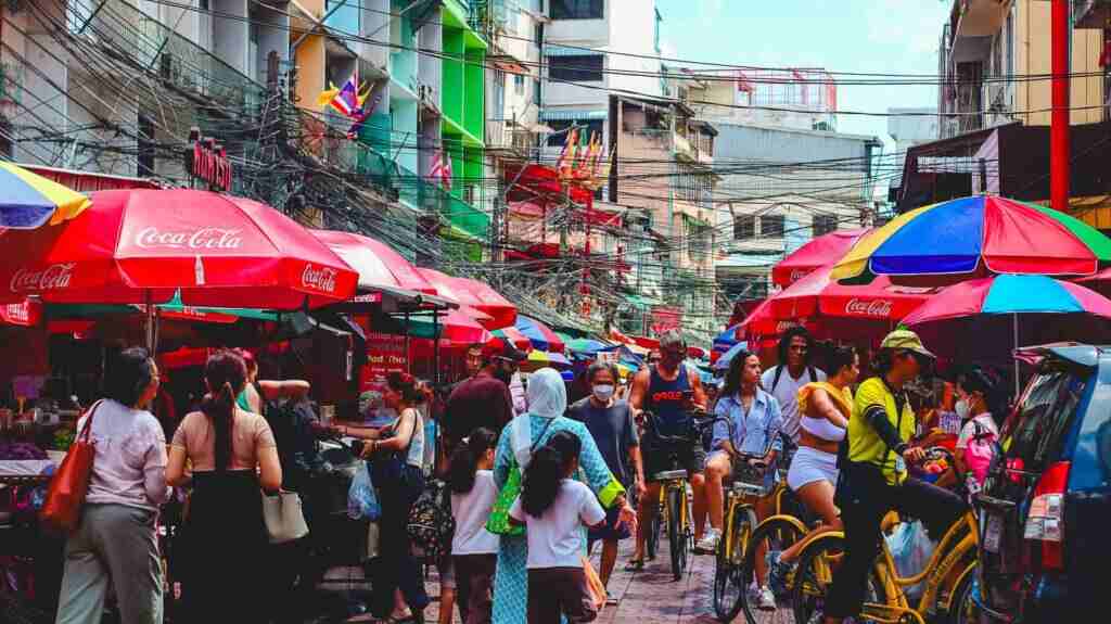 People shopping in china town bangkok min Busy local Chinatown market with intricate overhead power cables in Bangkok.