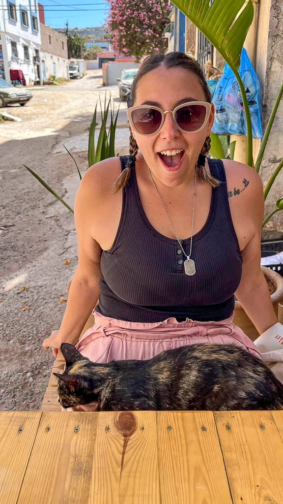 Ale sitting outside Zawaya coffee and the cat sitting on her lap