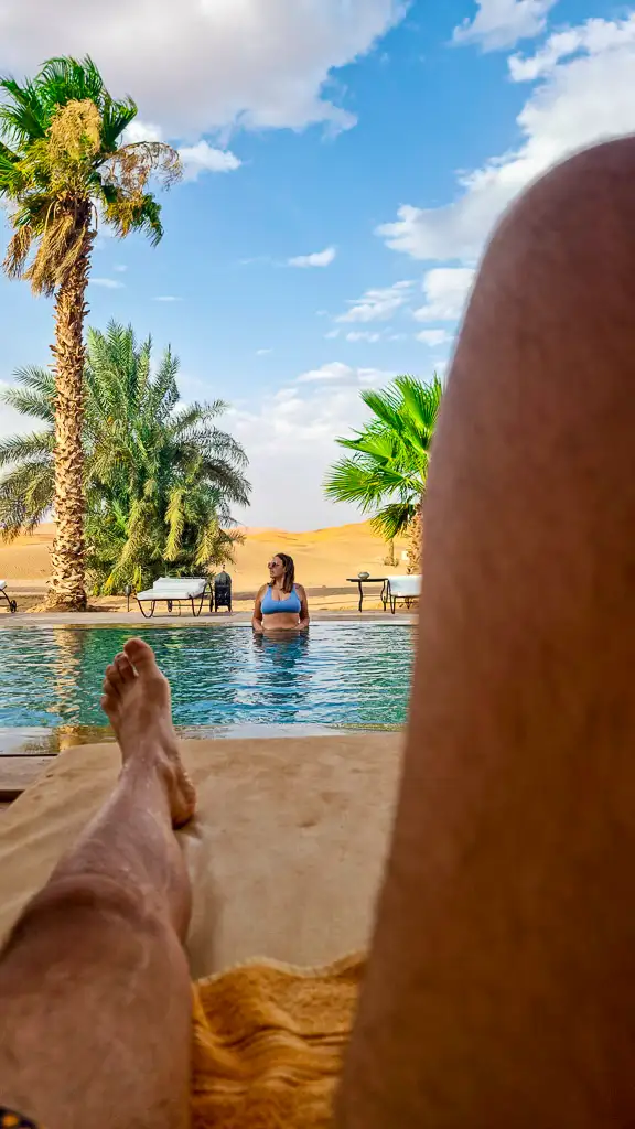 Beautiful shot couple Sahara Desert Morocco Pool Enjoying Merzouga desert from the pool of our accommodation - Hotel Kanz Emmeral
