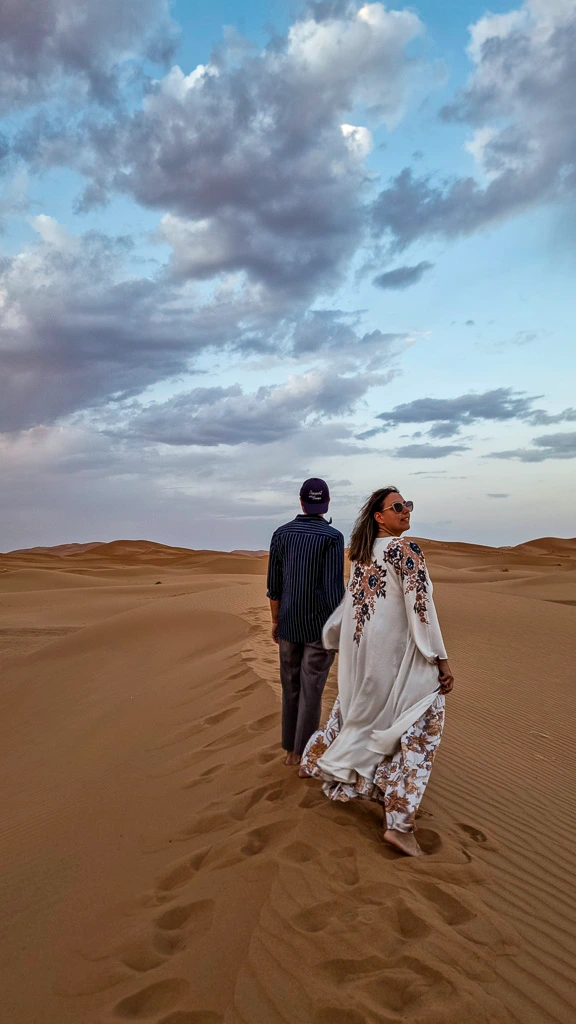 Couple walking desert dunes Morocco Toti walking around the streets of Hanoi - One month in Vietnam itinerary
