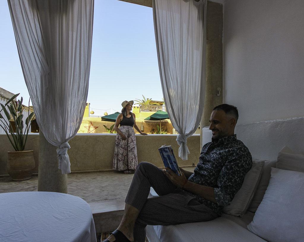 Toti reading a book and Ale drinking tea on the rooftop of Riad Tizwa - Unique things to do in Marrakech