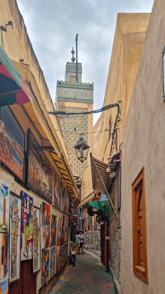 Artisan painted alley in Fes medina heart showing thousand colours on walls and ground - Rainbow Alley Rue Tala’a Kebira in Fes medina with painted walls artisan shops and colourful floor