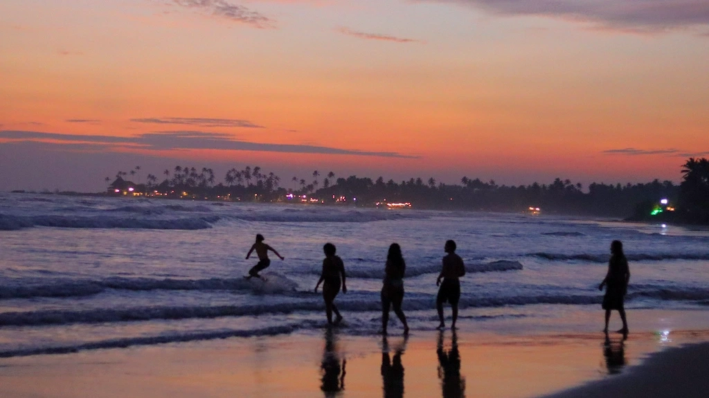 The trendy atmosphere in Hiriketiya with people swimming at sunset Sunset on the beach - Enjoying a walk along the Beach in Hiriketiya ideal Hiriketiya for non-surfers