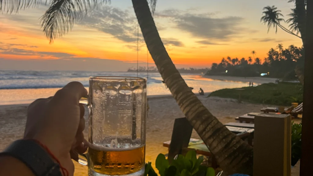 Enjoying a beer on the beach with a gorgeous sunset view
